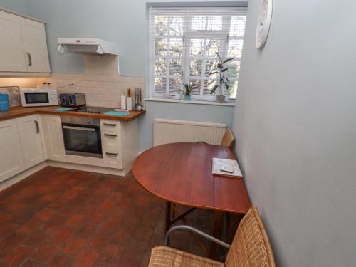 a kitchen with a wooden table in a kitchen at Ashfield Studio in Usselby