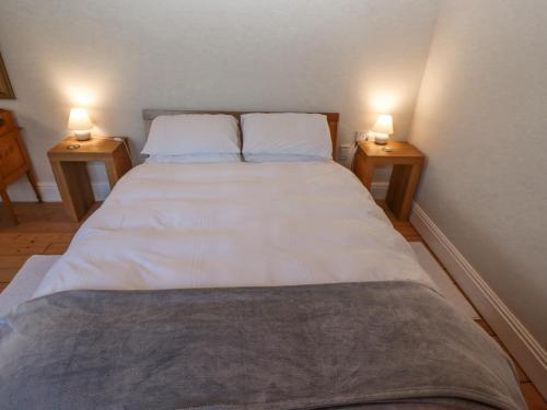 a bedroom with a bed with two lamps on both sides at Ashfield Studio in Usselby