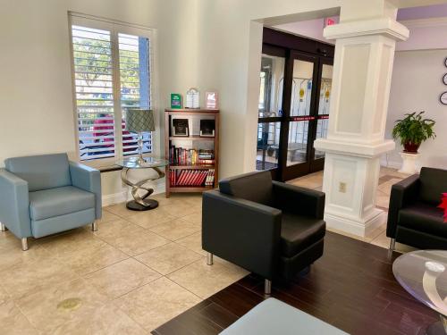 a living room with two chairs and a couch at Days Inn & Suites by Wyndham Lakeland in Lakeland