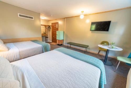 a hotel room with two beds and a table at The Springs Motel in New Ashford