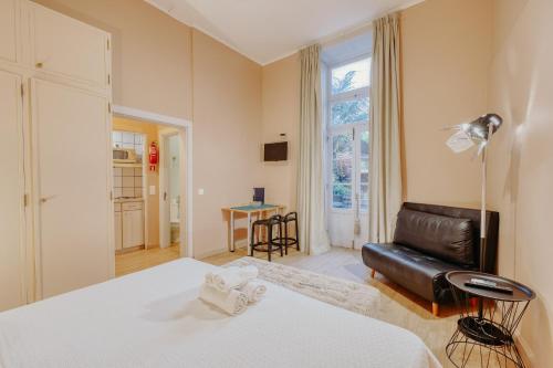 een slaapkamer met een bed, een bank en een tafel bij ASPA - Alegria Studios in Funchal