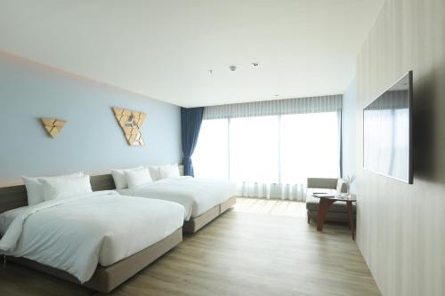 a hotel room with two beds and a window at The Signature Hotel Airport in Hat Yai
