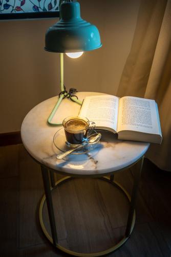 a table with a book and a cup of coffee and a lamp at Camino Verde B&B Monteverde Costa Rica in Monteverde Costa Rica