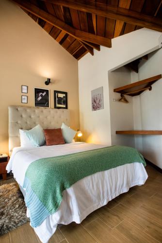 a bedroom with a large bed with a green blanket at Camino Verde B&B Monteverde Costa Rica in Monteverde Costa Rica