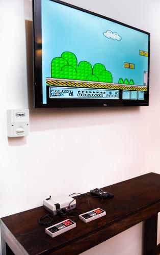 a flat screen tv hanging on a wall withintendo wii game controllers at Camino Verde B&B Monteverde Costa Rica in Monteverde Costa Rica