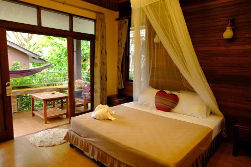 ein Schlafzimmer mit einem Himmelbett in der Unterkunft Pen's Bungalow Koh Phangan in Thong Nai Pan Yai