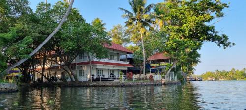 a house on a island in a body of water at Chilanka Lake View Resort in Alleppey
