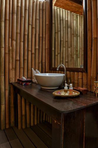 a bathroom with a counter with a sink and a mirror at The Gemalai Village in Pantai Cenang