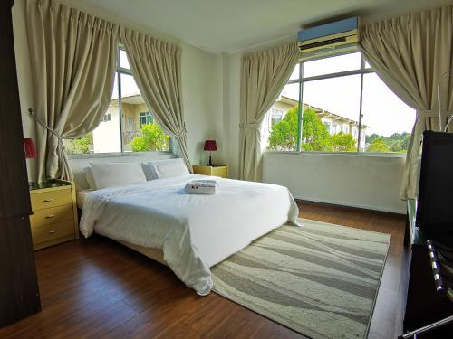 a bedroom with a white bed and a large window at Eden Penthouse Airport Access By Natol Homestay- Kuching Home in Kuching