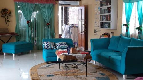 a living room with two blue couches and a table at D-Rima Homestay Ruteng in Ruteng
