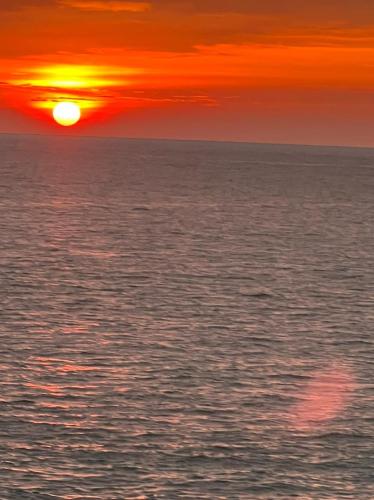 a sunset over the ocean with the sun setting at One World Mirissa in Mirissa