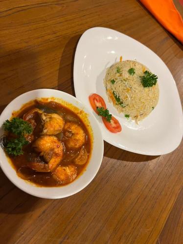 a plate of food with a bowl of shrimp and rice at One World Mirissa in Mirissa