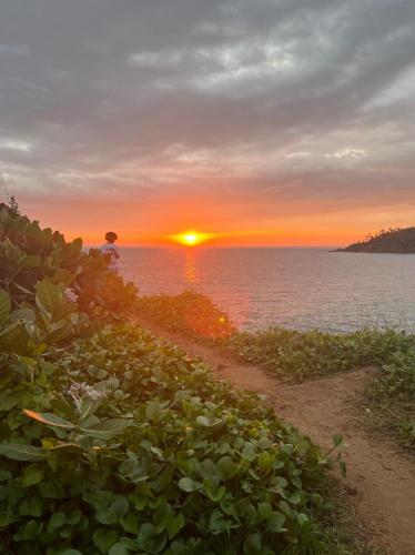 a sunset over the ocean with a dirt road at One World Mirissa in Mirissa