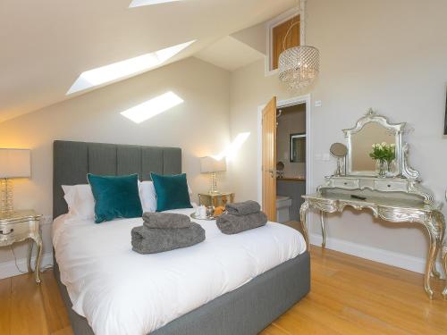 a bedroom with a large white bed with blue pillows at 7 Four Seasons in St Ives