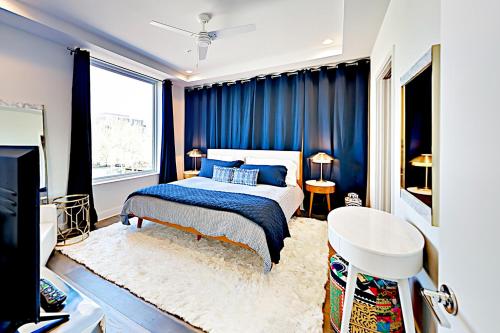 a bedroom with blue curtains and a bed and a desk at Fourth& #263 in Austin