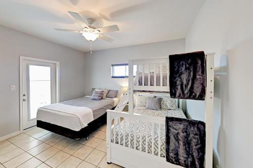 a bedroom with two bunk beds and a ceiling fan at Gulf Breezes & Dune Dreams in Port Aransas