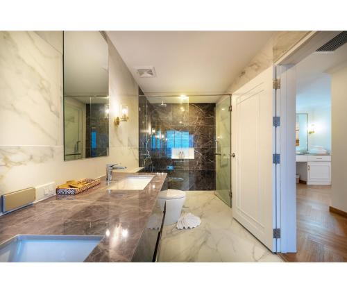 a bathroom with a tub and a sink and a toilet at Nine River Hotel in Ratchaburi