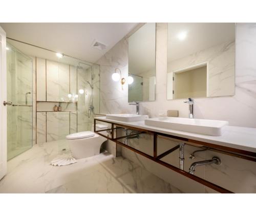 a bathroom with two sinks and a toilet at Nine River Hotel in Ratchaburi