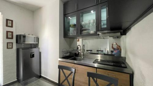 a kitchen with a sink and a refrigerator at Depa Rayas - Zona turística Guanajuato in Guanajuato