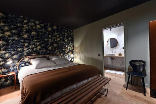 a bedroom with a large bed and a chair at L'Avancée Chalet contemporain au coeur du Sancy AUVERGNE in Murat-le-Quaire
