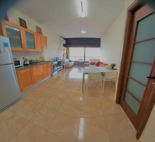 a kitchen and dining room with a table and a refrigerator at Panorama Bay View 3 room in Haifa