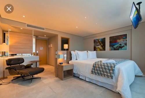a hotel room with a bed and a desk and a television at Bugan - Paiva Home Stay A&F in Recife