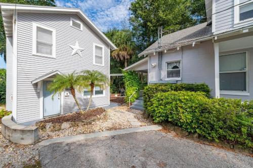 une maison blanche avec un palmier en face dans l'établissement Historic Tremain Cottages, à Mount Dora