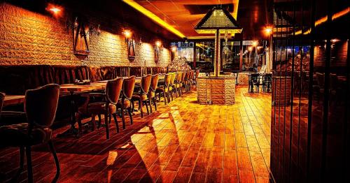 bar z krzesłami i stołami oraz ceglaną ścianą w obiekcie Eriza Boutique Hotel w mieście Erzincan
