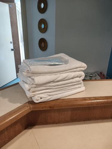 a stack of towels sitting on a counter in a bathroom at CosY Klebang Homestay in Kampong Lereh