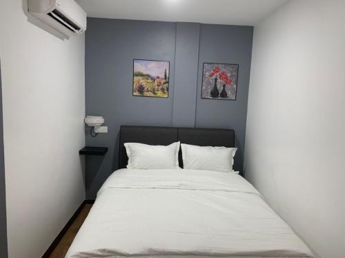 a bed in a room with two pictures on the wall at Hi TechSTAY in Lunas