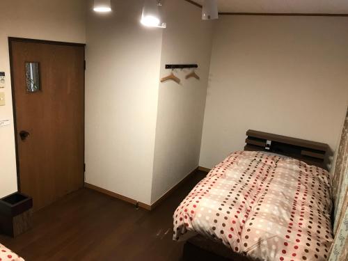 a bedroom with a bed in the corner of a room at Nagasaki Kagamiya in Nagasaki
