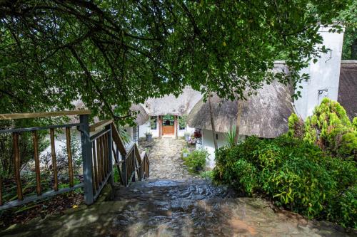 a path leading to a house with a thatch roof at Waterford Manor in Rosetta