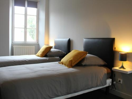 1 Schlafzimmer mit 2 Betten und gelben Kissen in der Unterkunft Gîte Val de Briey, 3 pièces, 4 personnes - FR-1-584-105 in Briey