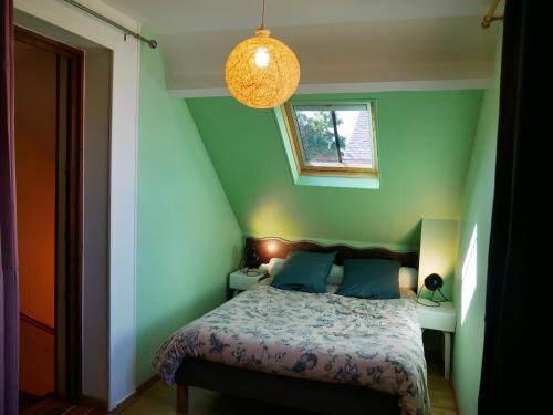 a bedroom with green walls and a bed with blue pillows at Charmante Maison pour 6 à St Père-sur-Loire, Vue Loire - FR-1-590-178 in Saint-Père-sur-Loire
