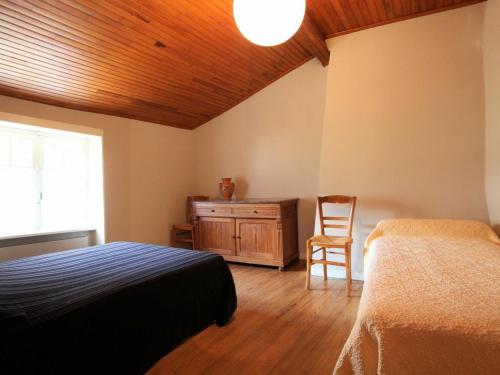 布萊勒的住宿－Gîte Blesle, 3 pièces, 4 personnes - FR-1-582-14，一间卧室设有两张床和木制天花板