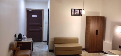 a room with a chair and a desk and a door at The Jamun Tree in Muzaffarpur