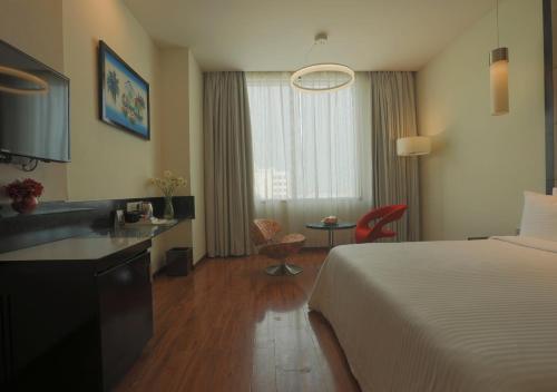 a hotel room with a bed and a bathroom at E Hotel in Chennai