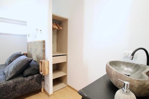 La salle de bains est pourvue d'un lavabo sur une table et d'un canapé. dans l'établissement Le Jardin d'Érables St Remy 7 HA Piscine/Clim, à Paluds de Noves