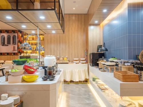 a large kitchen with a counter with dishes on it at 银座佳悦精选（菏泽郓城水浒城店） in Yuncheng