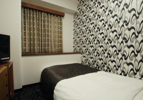 a hotel room with a bed and a window at APA Hotel Kanazawa-Nomachi in Kanazawa