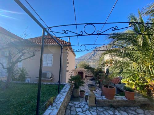 a garden with potted plants and a house at Casa Pasinovic in Kotor