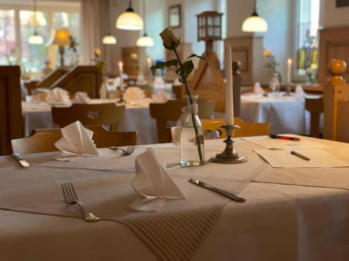 una mesa con un mantel blanco con un jarrón de flores. en Landgasthof Kaiser, en Bieringen