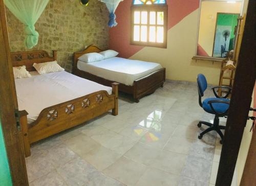 a bedroom with two beds and a chair in it at Temple Flower Guest in Kirinda