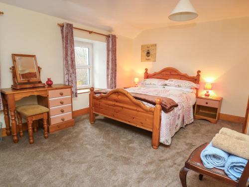 a bedroom with a bed and a dresser and a mirror at Waun Fforest in Rhyd-cymmerau