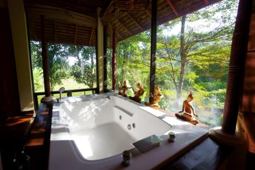 a group of people sitting around a bath tub in a room at Sukantara Cascade Resort and Spa in Mae Rim
