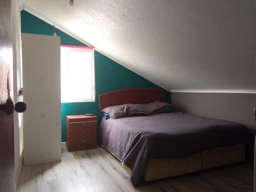 コキンボにあるLos Arrayanes Hostelの緑の壁、ベッド付きのベッドルーム1室