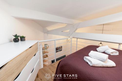 une chambre avec un lit avec des serviettes dessus dans l'établissement Studio Fleur FSHH, à Nice