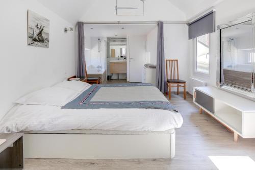 Habitación blanca con cama y ventana en Le Martray - Appartement coeur historique de Paimpol, en Paimpol