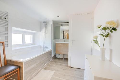 a bathroom with a tub and a sink at Le Martray - Appartement coeur historique de Paimpol in Paimpol