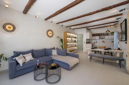 a living room with a blue couch and a kitchen at Casa di Grimpili in Kolymvari